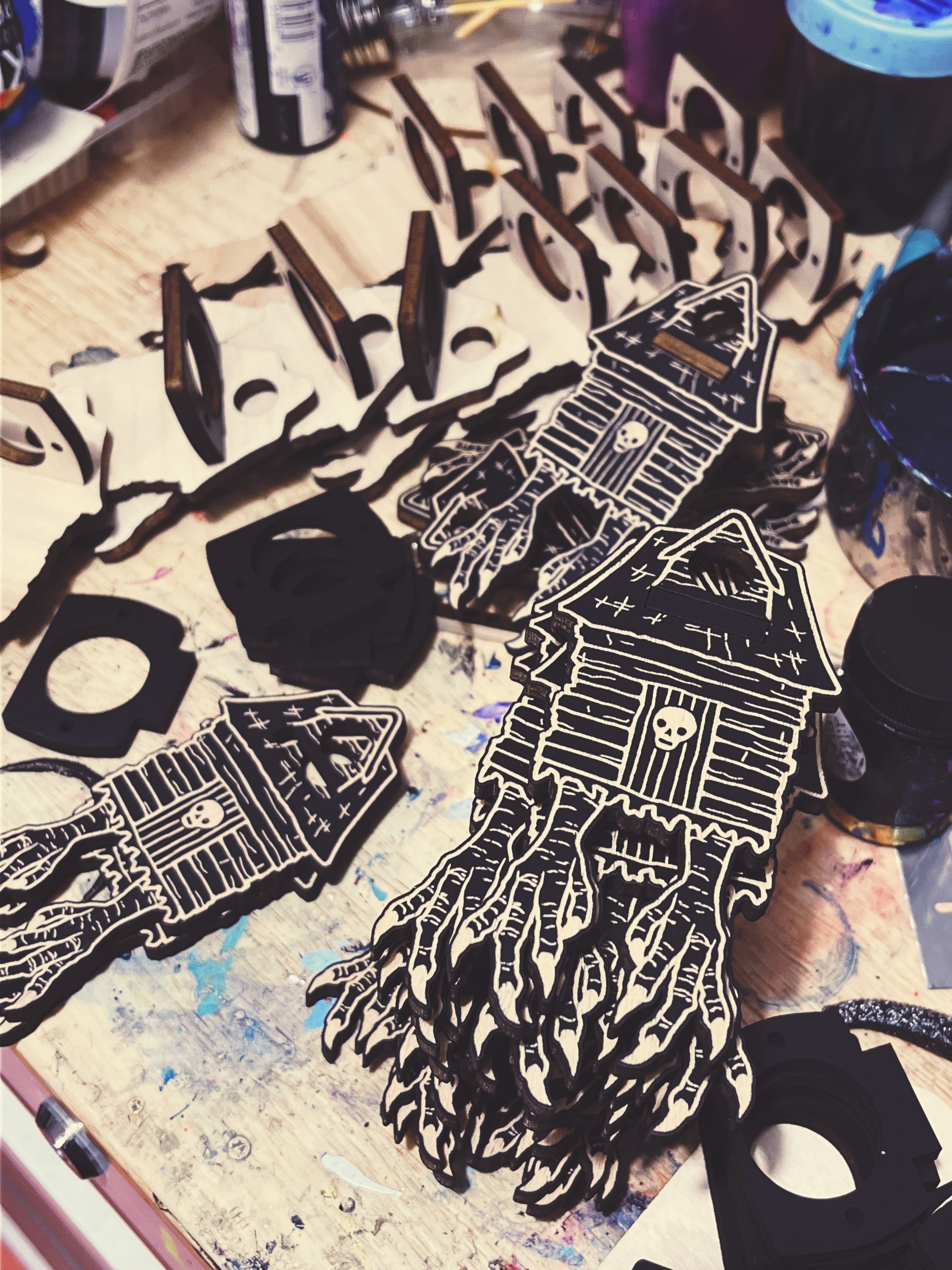 Wooden cut-outs of Baba Yaga's Hut arranged on the surface of a workbench